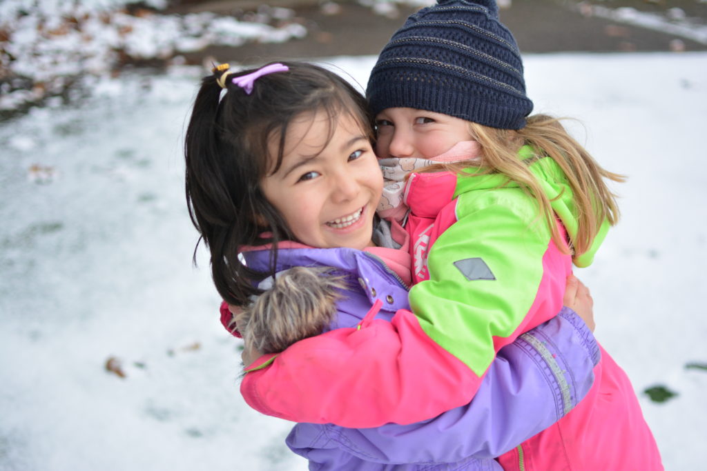 2 kindergarten students playing in the snow