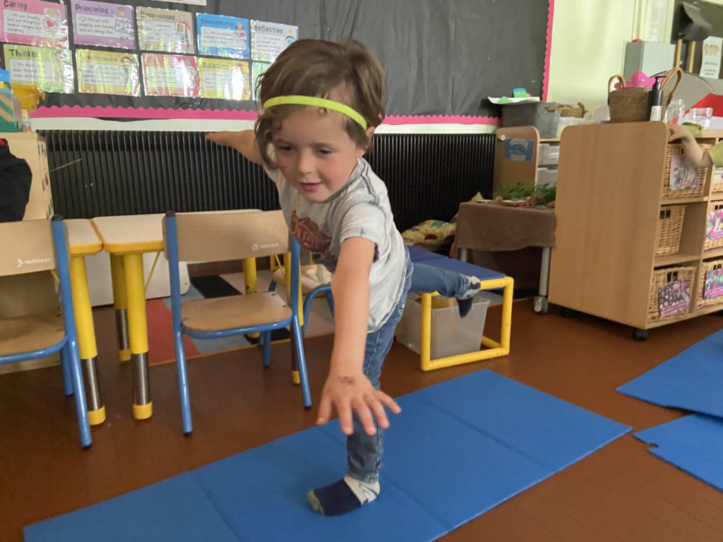 A kindergarten student doing a yoga pose