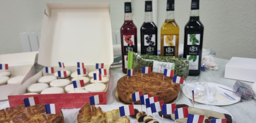 Pastries and juice arranged on a table with French flags as decoration