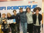 Students from the ISL Robotics team posing in front of a sign reading "First Tech Challenge Robotique"