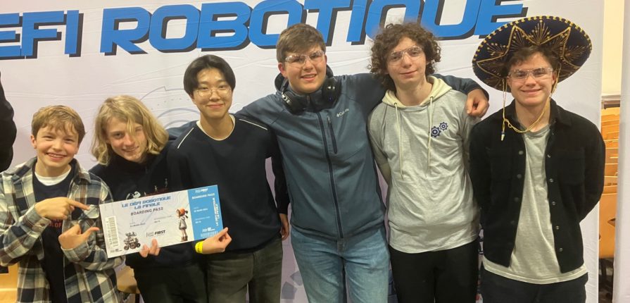 Students from the ISL Robotics team posing in front of a sign reading "First Tech Challenge Robotique"